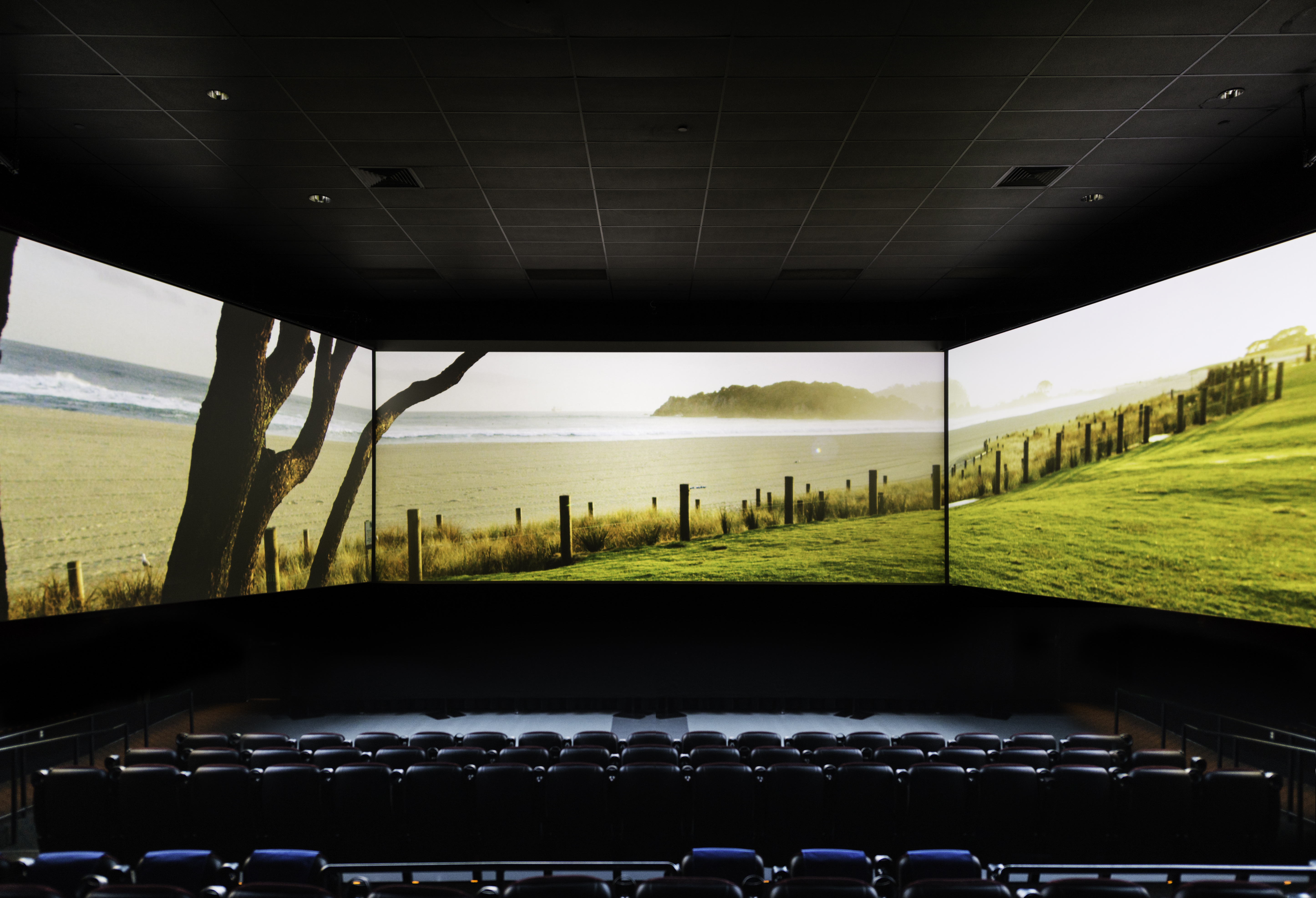 Кинотеатр с самым большим экраном. Кинотеатр с 3 экранами. Кинотеатр с тремя экранами. Панорамный экран кинотеатр. Сцена с панорамным экраном.